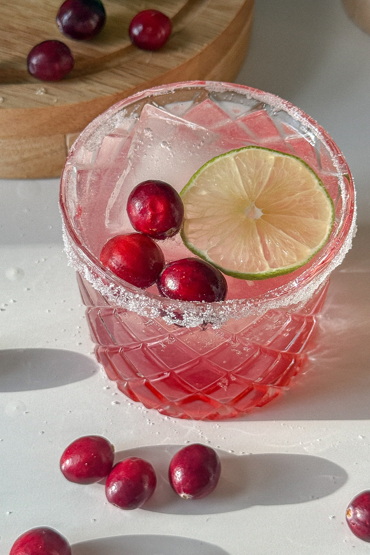 Cranberry Moscow Mule in a glass garnished with sugar, lime and fresh cranberries