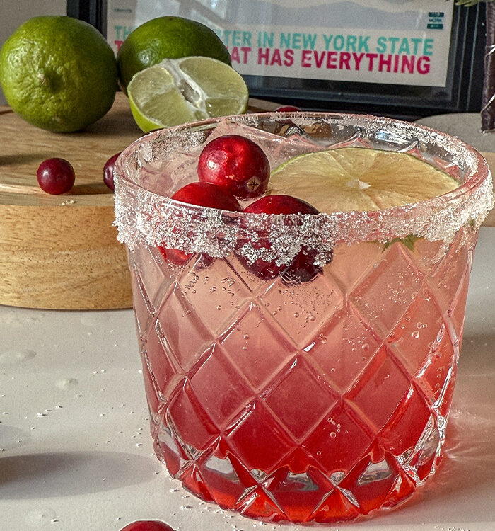 Cranberry Moscow Mule in a glass garnished with sugar, lime and fresh cranberries