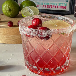 Cranberry Moscow Mule in a glass garnished with sugar, lime and fresh cranberries