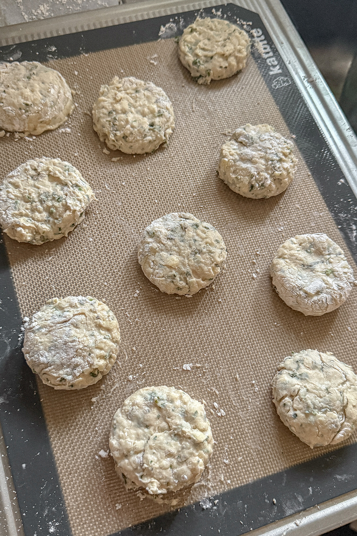 White Cheddar Herb Biscuit dough rounds on a baking sheet